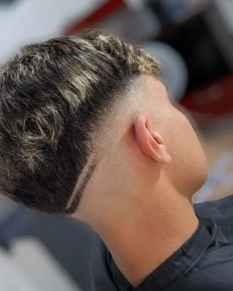 Ricci con mèches e linea disegnata – taglio uomo StreetBarber